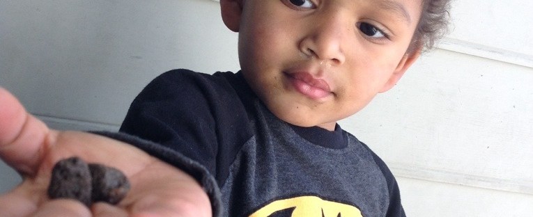 The kid holding dirt balls.