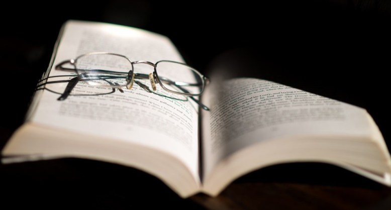 Reading Glasses Resting On Open Book